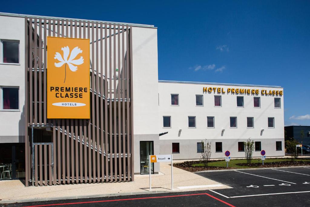 a building with a sign on the side of it at Première Classe Chartres Sud - Barjouville in Chartres