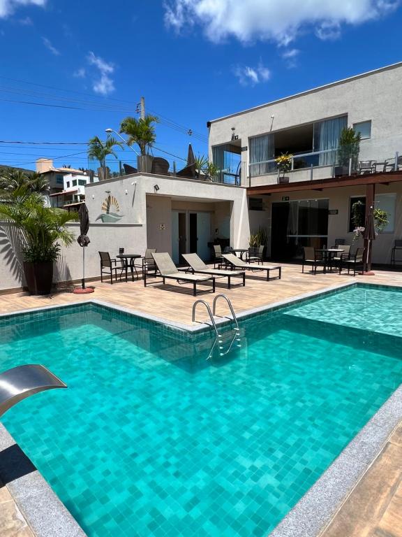 a swimming pool in front of a house at Pousada Viver Capitólio in Capitólio