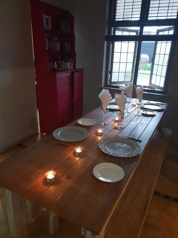 a wooden table with plates and candles on it at Journey Guesthouse in Riversdale