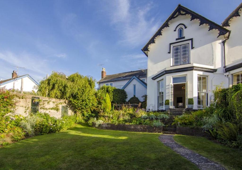 a white house with a garden in front of it at Salty House Shaldon in Shaldon