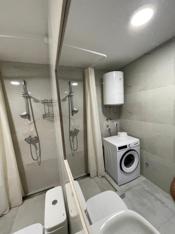 a bathroom with a toilet and a washing machine at Skopje City VIew in Skopje