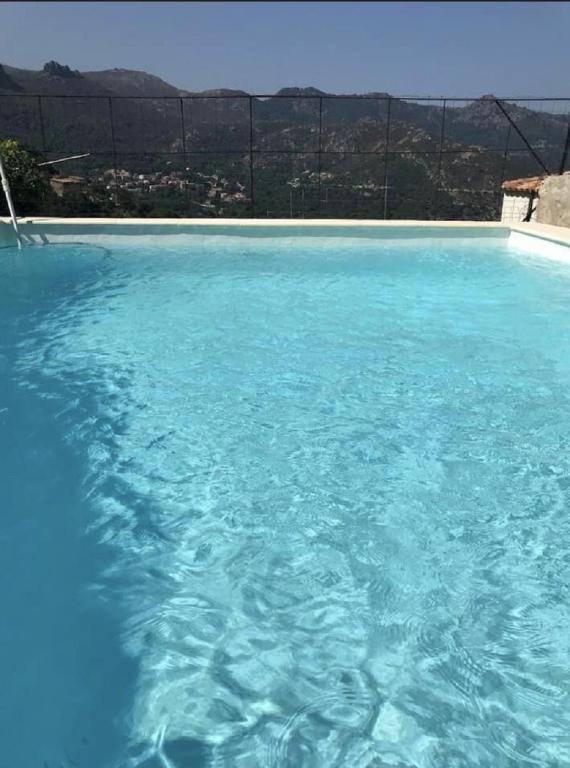 une grande piscine d'eau bleue avec vue dans l'établissement Casa Orsini, à Nessa