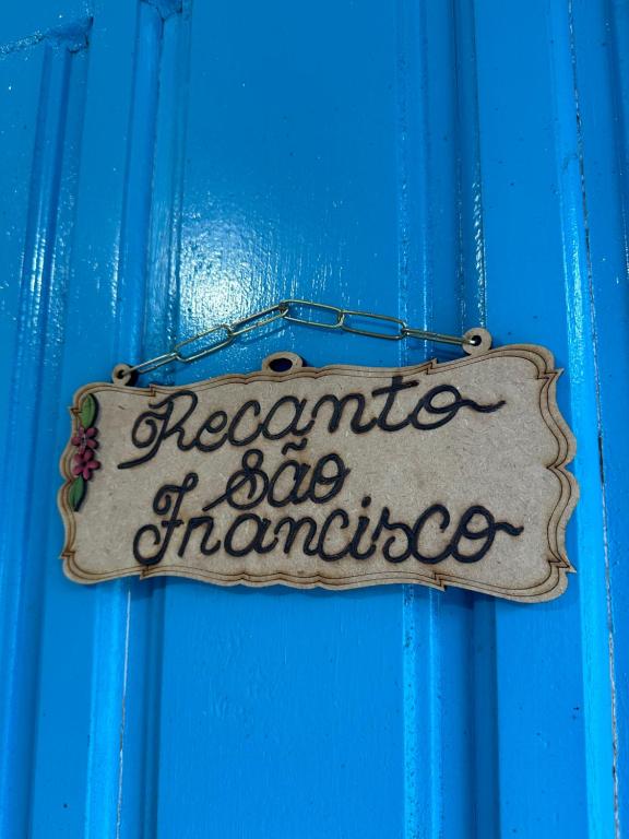 a sign on the door of a blue door at Recanto São Francisco in Campos do Jordão