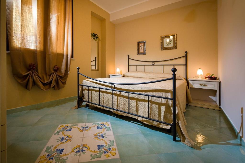 a bedroom with a bed and a rug on the floor at Appartamenti il Patio in San Vito lo Capo