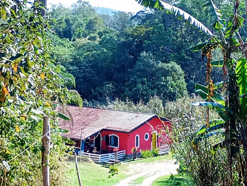 a red barn in the middle of a forest at O Brejo Encantado Hospedagem e Pousada in Embu
