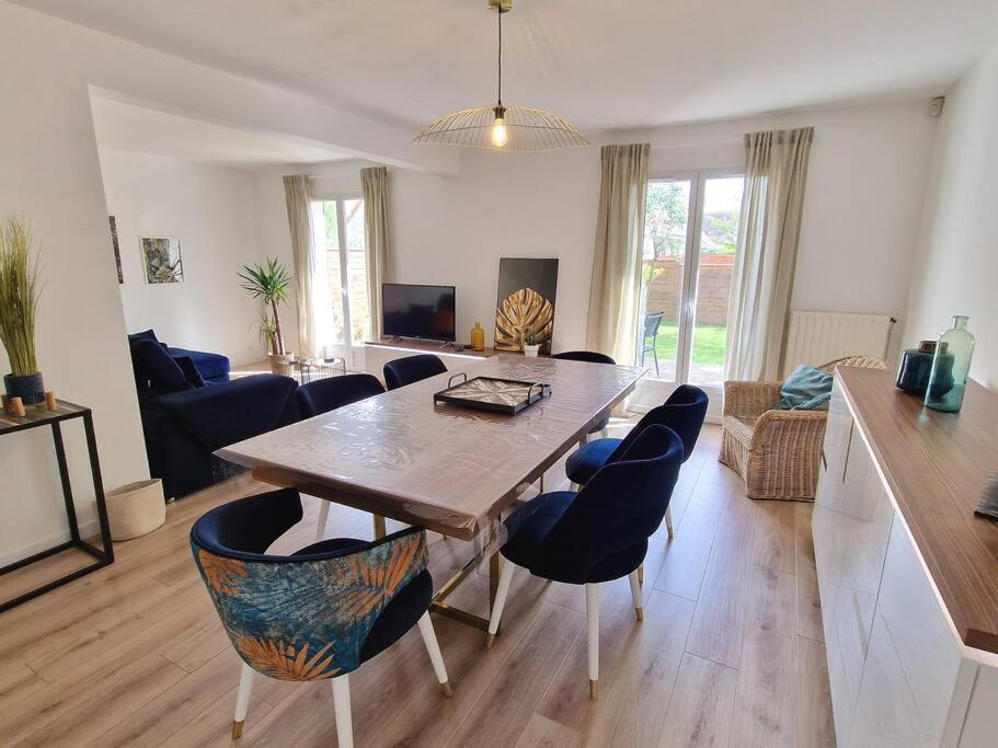 uma sala de estar com uma mesa de madeira e cadeiras em Les Glazons *T4* Olivet + Parking em Olivet