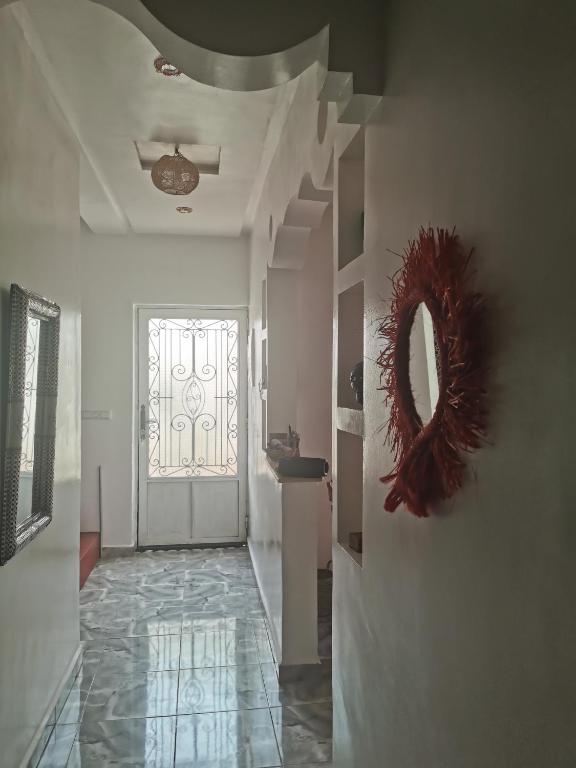 een hal met een deur en een spiegel aan de muur bij Chez Marie in Al Ghar