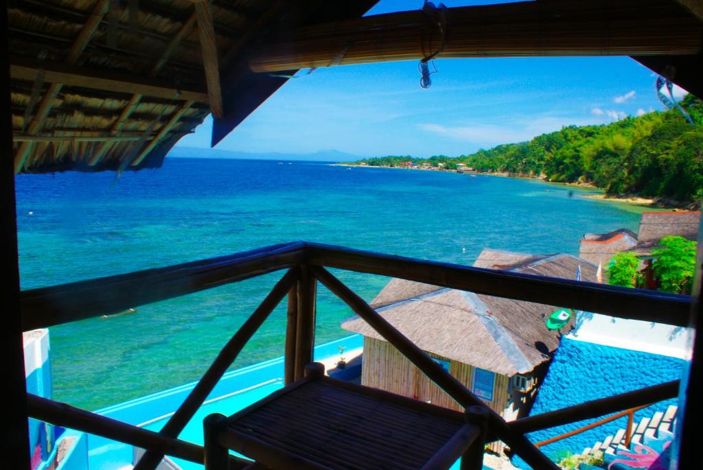 a view of the ocean from the balcony of a resort at MLK Bamboo Beachhouse in Alegria