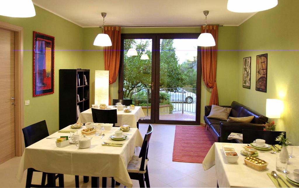 un comedor con 2 mesas y un sofá en Kianna Bed&Breakfast, en Dorgali