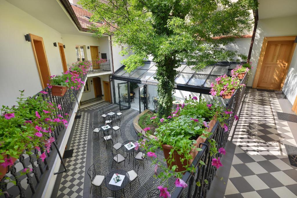 uma vista superior de um pátio com plantas e flores em Hotel At the White Lily em Praga