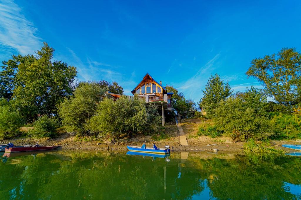 Jarak的住宿－Savski Mir，两艘船在湖岸边的房子