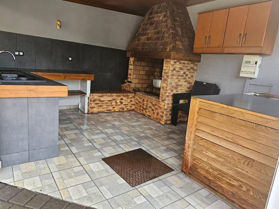eine Küche mit einem Backsteinofen in der Mitte in der Unterkunft Ô Paradis caché à Saint-Joseph in Saint-Joseph
