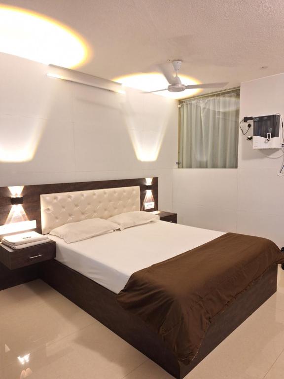 1 dormitorio con 1 cama grande y TV en Suvarna Grande Homes en Mangalore
