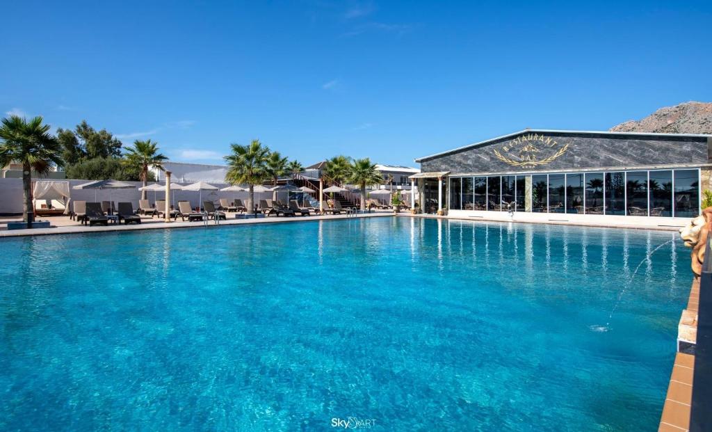 a large pool with blue water in front of a resort at Paradice Hotel Luxury Suites-Near zorbas Beach-FREE Breakfast in Stavros