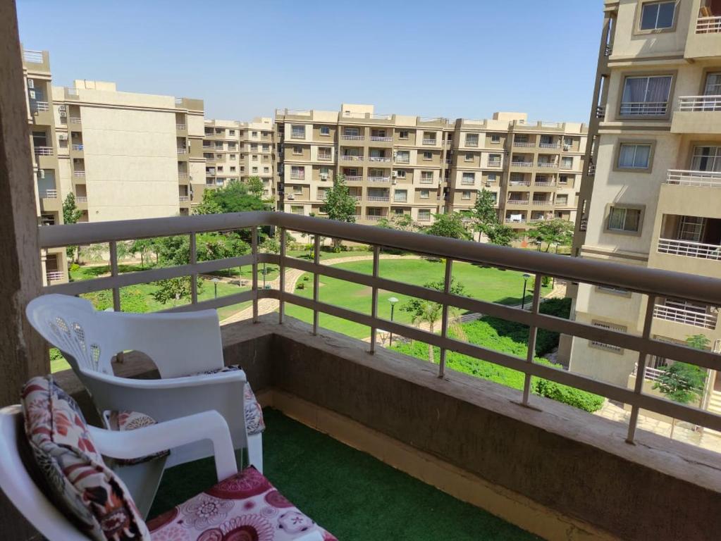 a balcony with a chair and a view of a building at Madinty Modern 2 rooms apartment at Madinty city for families only مدينتي in Madinaty