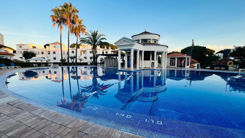 a large swimming pool in front of a house at Charming triplex T2 in the Old Village Vilamoura in Quarteira