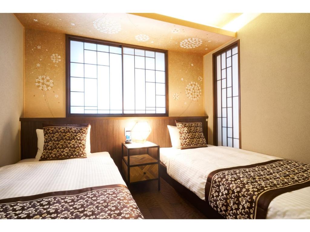 - 2 lits dans une chambre avec 2 fenêtres dans l'établissement SHIKI Seasonal Colors Kanazawa - Vacation STAY 46392v, à Kanazawa