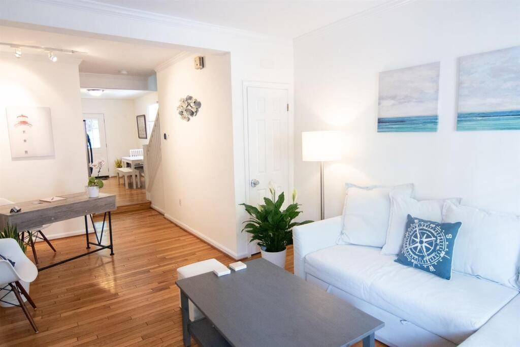 a living room with a white couch and a table at Cozy 2br home w/ parking in downtown Annapolis in Annapolis