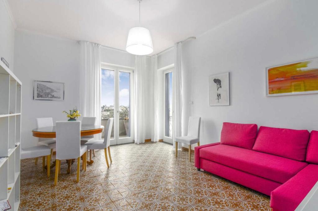 sala de estar con sofá rosa y mesa en Casa Mansi, en Scala