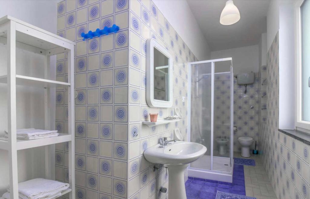 a white bathroom with a sink and a shower at Casa Mansi in Scala