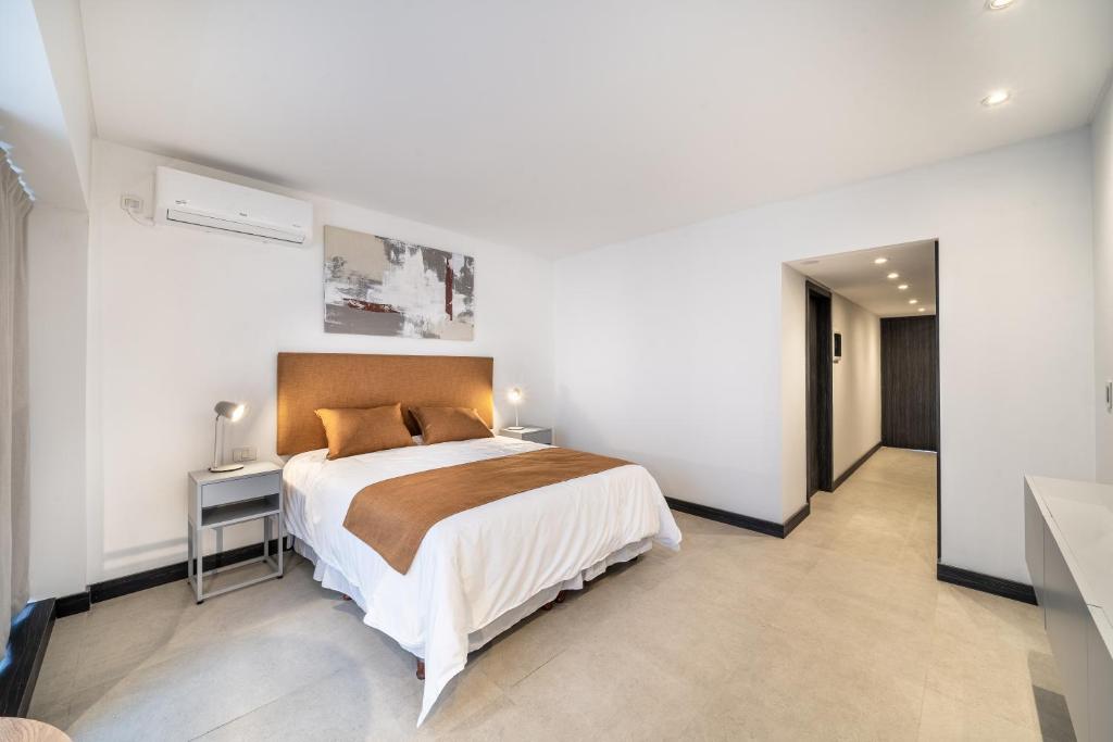 a bedroom with a large bed in a white room at La Vie Madero in Buenos Aires
