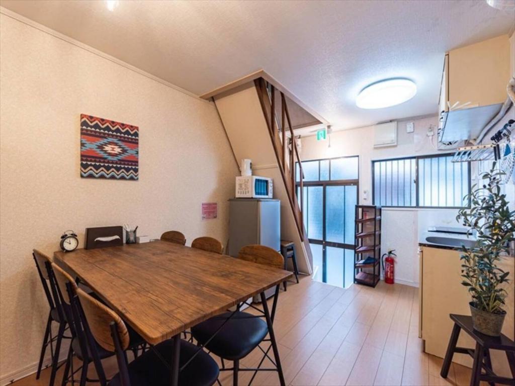 a kitchen and dining room with a wooden table and chairs at Chachamaru Osaka Castle Park - Vacation STAY 15422 in Osaka