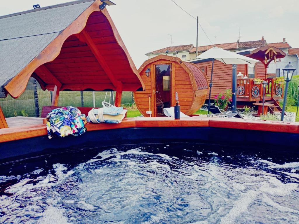 duży basen z wodą z dużym drewnianym domem w obiekcie Romantic Gipsy w mieście Ivrea