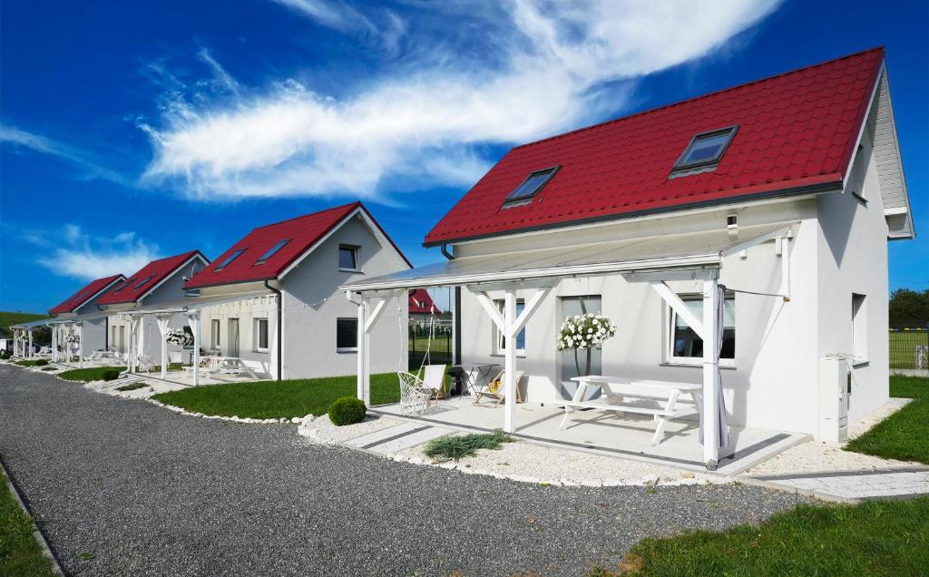 a row of white houses with a red roof at Domki całoroczne Jesionowscy in Kudowa-Zdrój