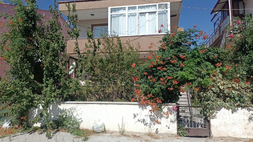 una casa con unas flores delante de ella en Bahçeli Müstakil Daire en Burhaniye