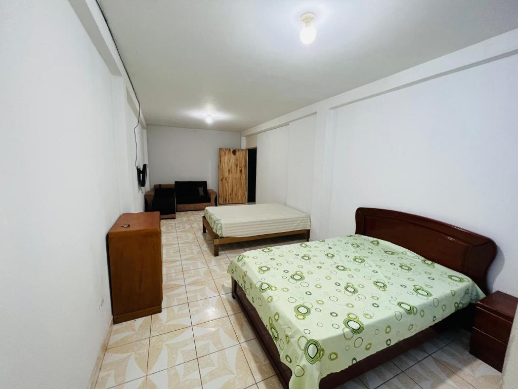 een slaapkamer met een bed en een stoel in een kamer bij La casa de Elena in Tingo María