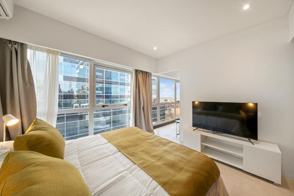 a bedroom with a large bed and a television at La Vie Suite Madero in Buenos Aires