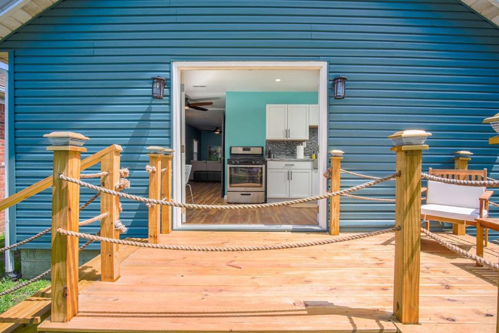 ein blaues Haus mit einer Holzterrasse und einer Küche in der Unterkunft Buckeye Lake Cottage in Hebron
