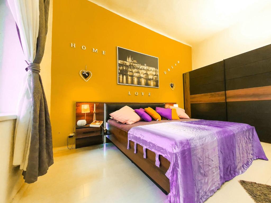 プラハにあるApartment in the center of Pragueのベッドルーム(紫色の掛け布団付きのベッド1台付)