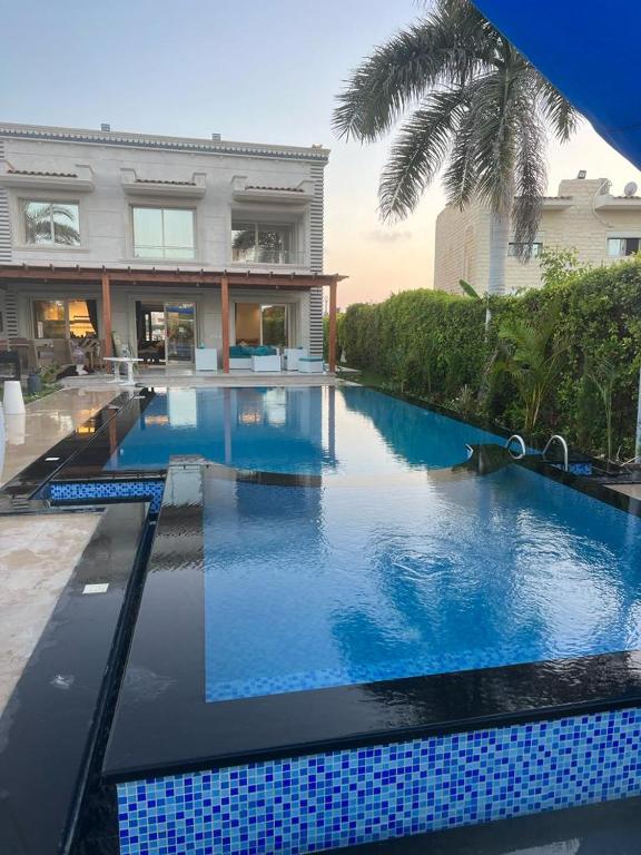uma grande piscina em frente a uma casa em Villa Marina 6 First Row on The Lake em El Alamein