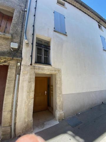 a white building with a door and a window at Appartement climatisé au pied du Mont Ventoux in Malemort-du-Comtat