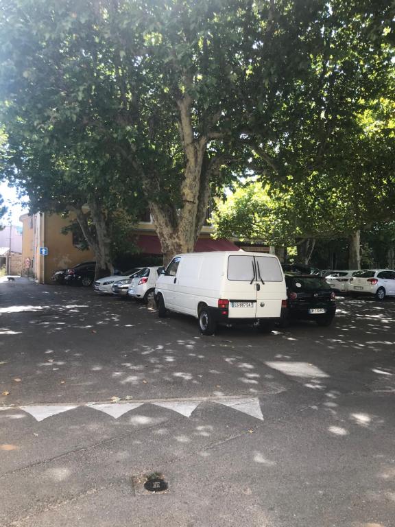 a white van parked in a parking lot with cars at Appartement climatisé au pied du Mont Ventoux in Malemort-du-Comtat
