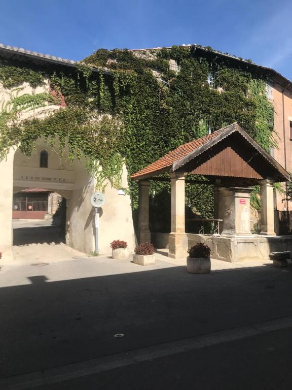 a building with ivy on the side of a street at Appartement climatisé au pied du Mont Ventoux in Malemort-du-Comtat