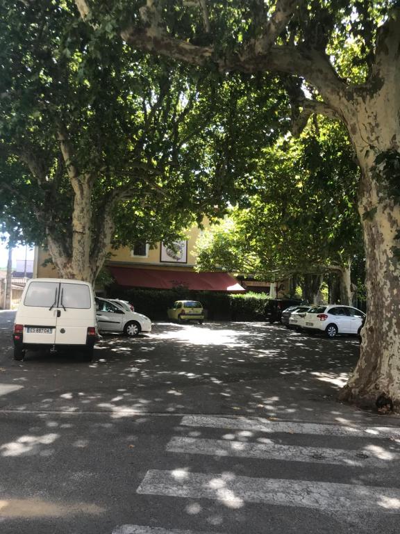 a white van parked in a parking lot with trees at Appartement climatisé au pied du Mont Ventoux in Malemort-du-Comtat