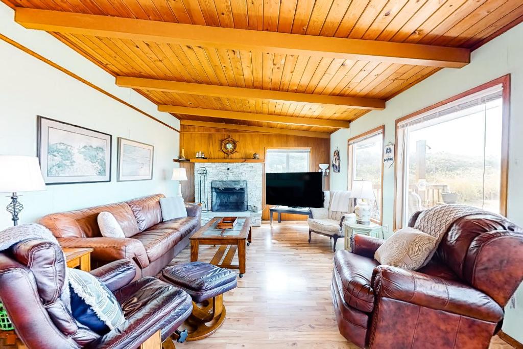 a living room with leather furniture and a fireplace at Sea Mist in Rockaway Beach