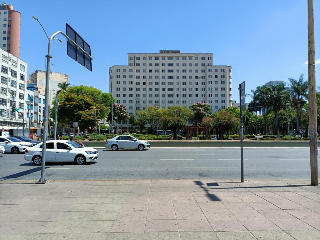 uma rua com carros a descer uma rua com edifícios em Apartamento Centro Belo Horizonte em Belo Horizonte