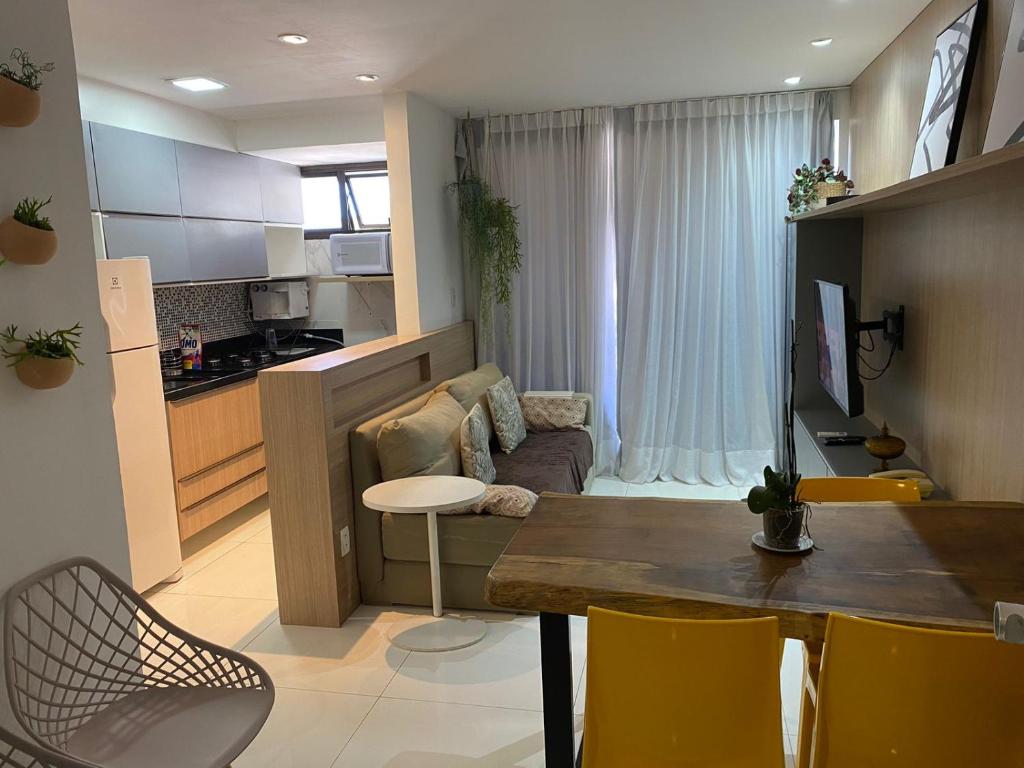 a kitchen and a living room with a table and chairs at Apto com visita mar, piscina, sauna, academia e serviço de limpeza in Rio de Janeiro