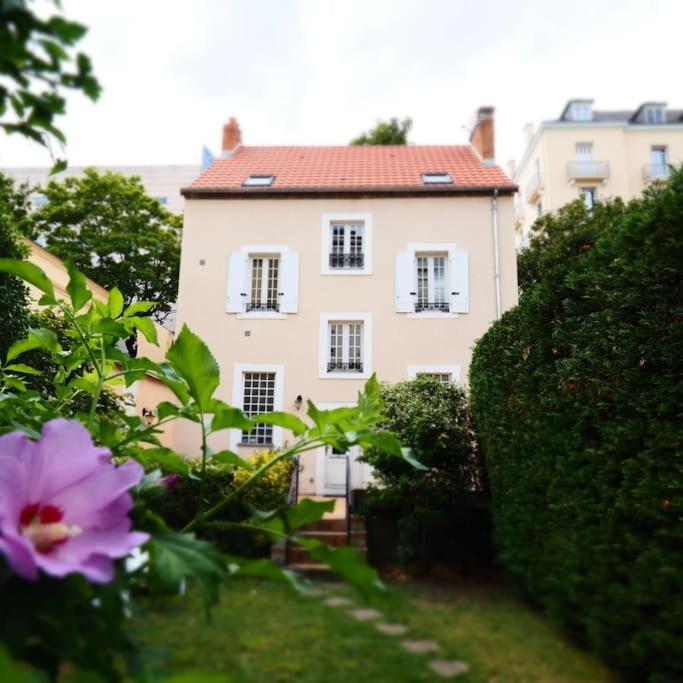 une grande maison blanche avec un toit rouge dans l'établissement MAISON FAURE - Centre ville - Jardin - Garage, à Vichy