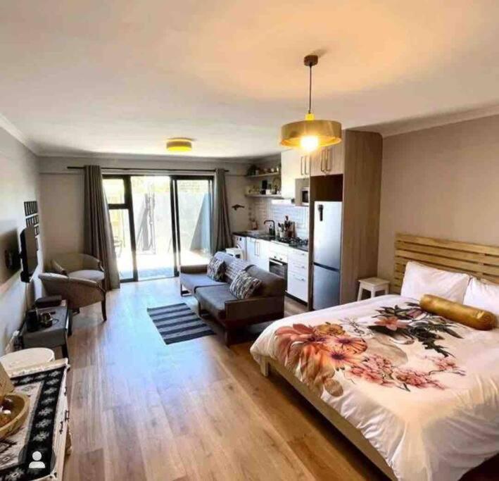 Un dormitorio con una cama y una sala de estar. en Blouberg Studio, en Ciudad del Cabo