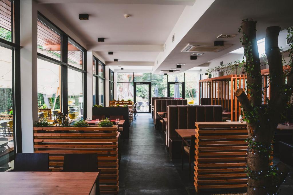 a restaurant with tables and chairs and windows at Utopia Village - Art & Nature Lodges in Jurbise