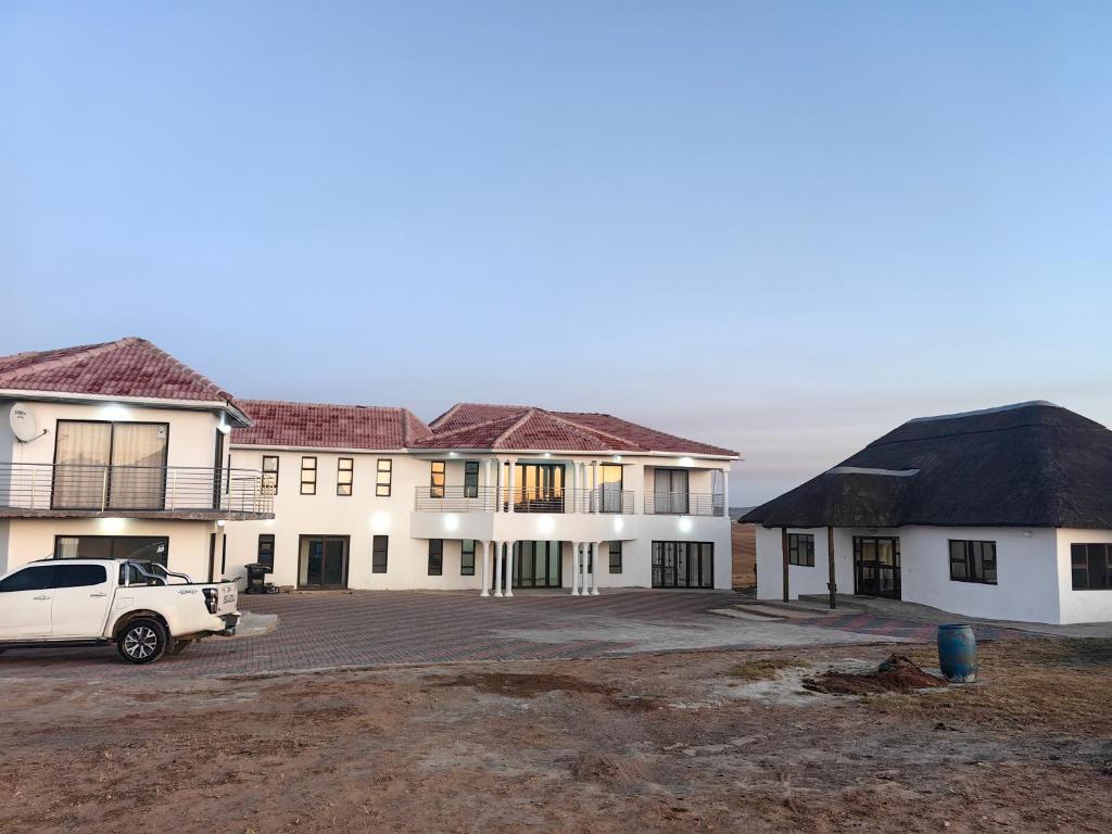 a white car parked in front of a building at Ngqamakwe Luxury Guest House and Conference Centre in Nqamakwe