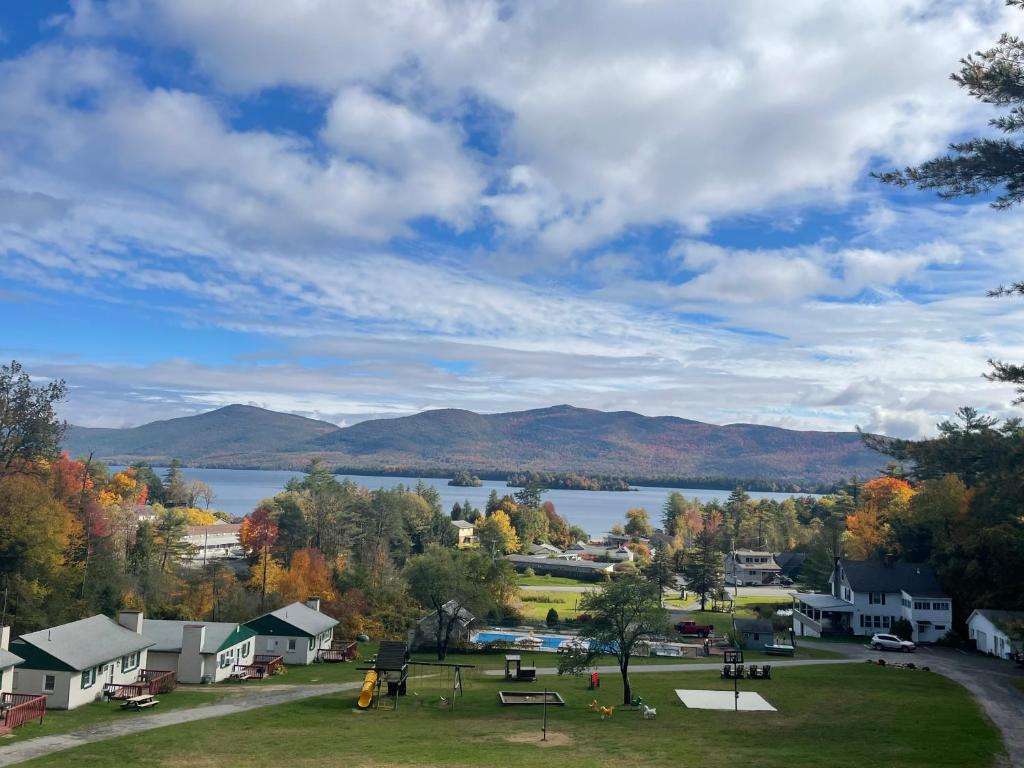 um parque com um lago e montanhas ao fundo em Hill View Motel and Cottages em Lake George