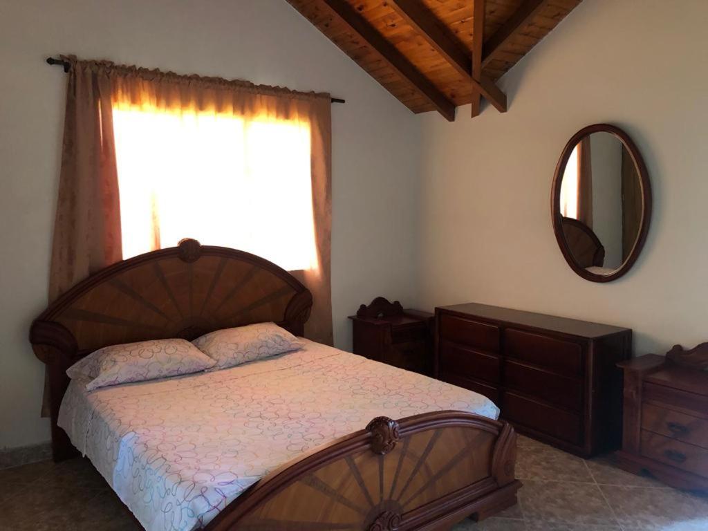 een slaapkamer met een bed, een raam en een spiegel bij Finca hotel boutique en el peñol in Guatapé