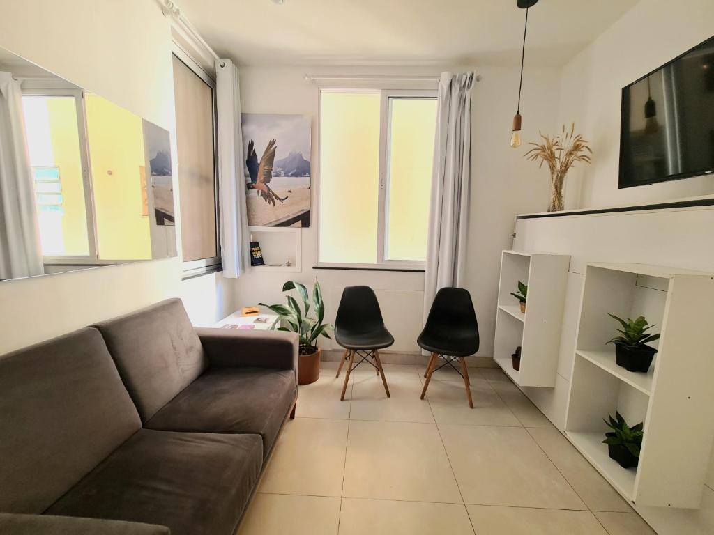 a living room with a couch and two chairs at Apto Versátil Praia de Botafogo in Rio de Janeiro