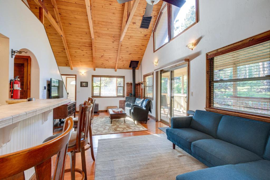 a living room with a blue couch and a kitchen at Serene South Lake Tahoe Getaway with Spacious Deck! in South Lake Tahoe