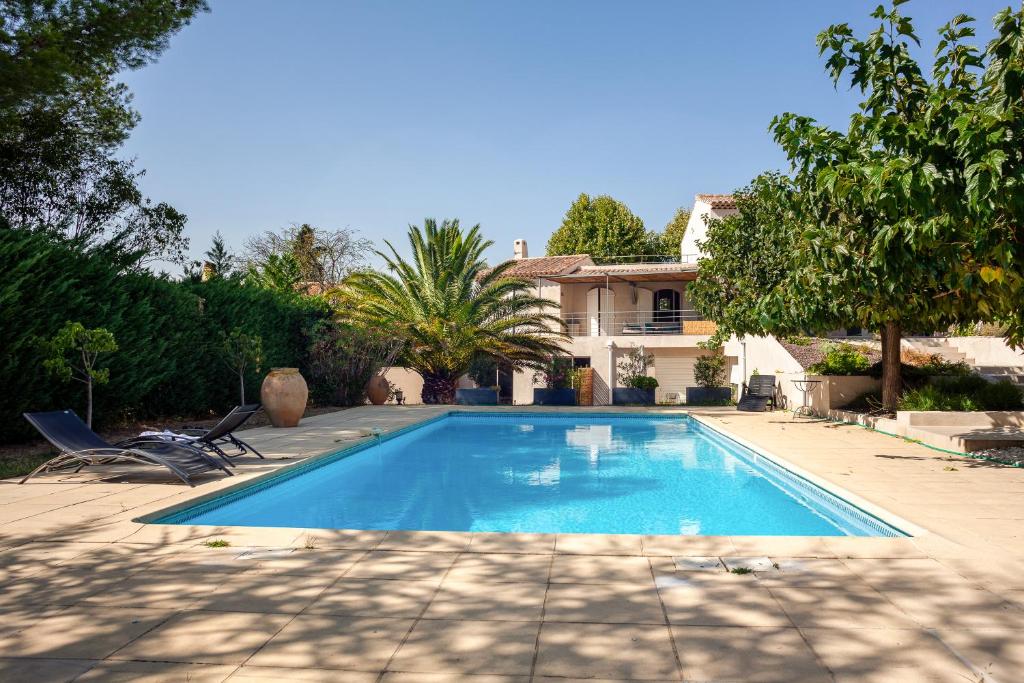 a swimming pool in front of a house at Cocon avec piscine et jardin in Marseille